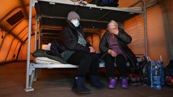 Люди в палатке временного размещения на контрольно-пропускном пункте Матвеев Курган в Ростовской области