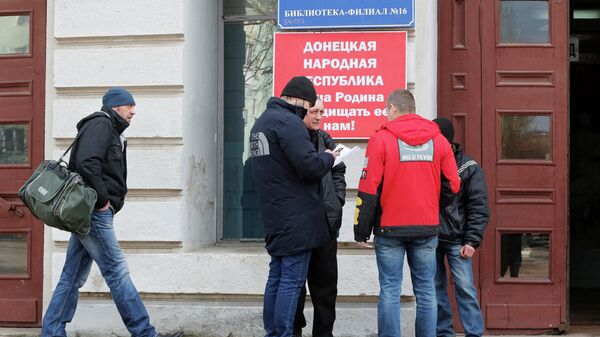 Мужчины у входа в мобилизационный пункт в Донецке