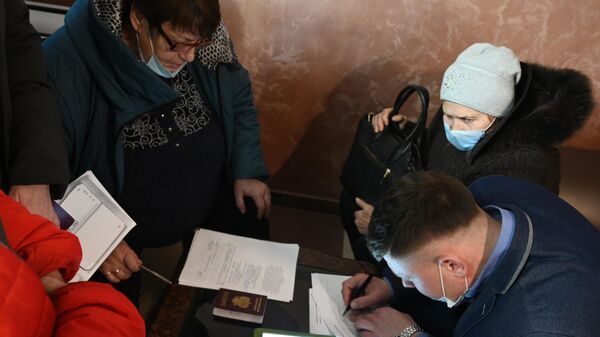Жители Донецкой и Луганской народных республик заполняют документы в пункте временного размещения беженцев, организованном в пансионате Звезда в Ростовской области