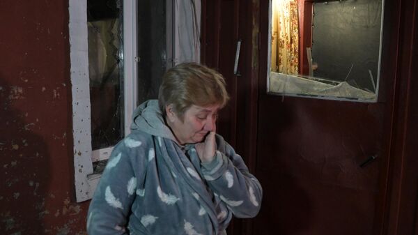 Женщина во дворе своего дома, пострадавшего в результате обстрела, в поселке шахты Трудовская в Донецке