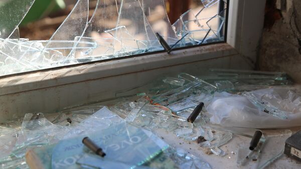 Разбитое окно и гильзы на подоконнике в жилом доме в Донбассе после обстрела ВСУ