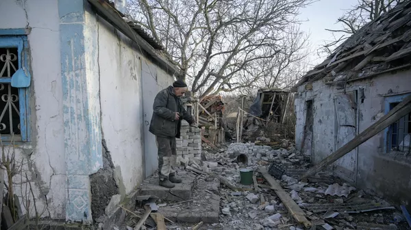 Ένας άνδρας στην αυλή του σπιτιού του, κατεστραμμένος από βομβαρδισμούς στο χωριό Taramchuk, στην περιοχή του Ντόνετσκ