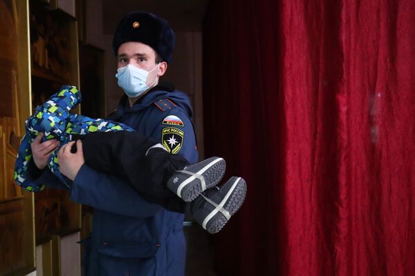 Сотрудник МЧС РФ с ребенком на руках во время размещения жителей Донецкой и Луганской народных республик в гостинице Ахтуба в городе Волжский