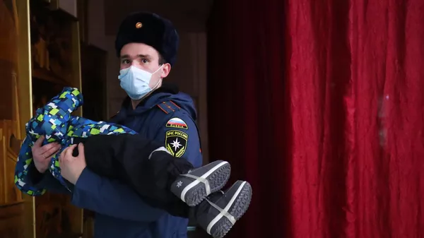 Υπάλληλος του Υπουργείου Καταστάσεων Έκτακτης Ανάγκης της Ρωσικής Ομοσπονδίας με ένα παιδί στην αγκαλιά της κατά τη διαμονή των κατοίκων των Λαϊκής Δημοκρατίας του Ντόνετσκ και του Λουγκάνσκ στο ξενοδοχείο Akhtuba στην πόλη Volzhsky