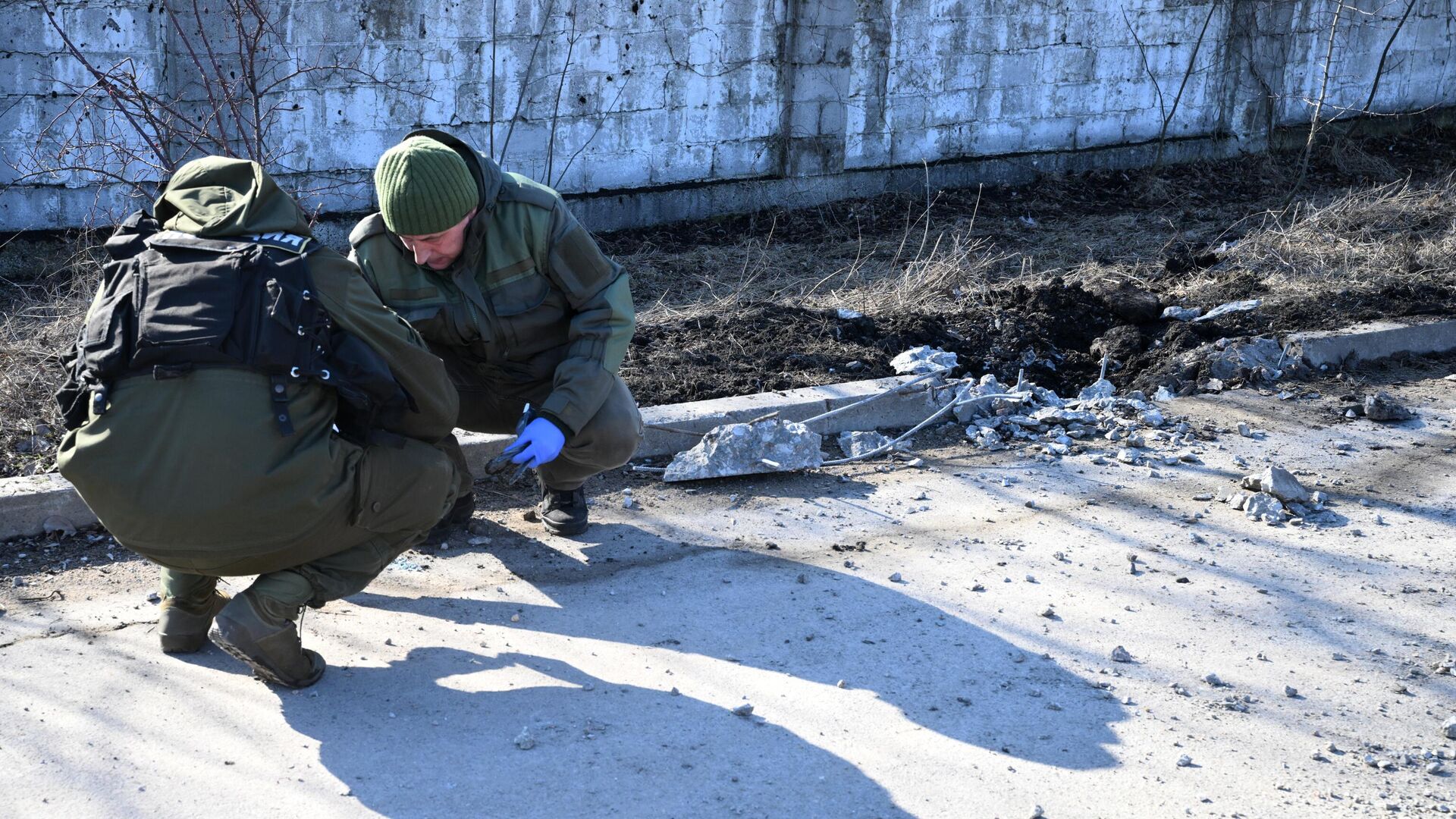 Сотрудники народной милиции ДНР осматривают место взрыва в Петровском районе Донецка - РИА Новости, 1920, 21.02.2022