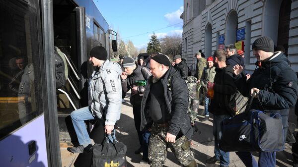 Люди садятся в автобус у сборного пункта военкомата в Кировском районе Донецка перед отправкой в действующие части