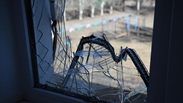 Поврежденные в результате обстрела окна в здании школы в Донбассе