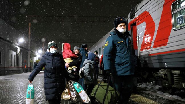 Сотрудник МЧС России сопровождает жителей Донецкой и Луганской народных республик, прибывших на железнодорожный вокзал в Нижний Новгород