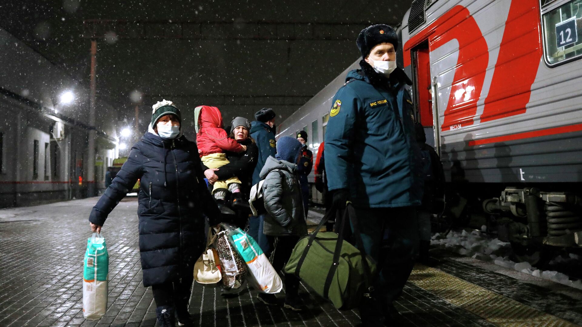 Сотрудник МЧС России сопровождает жителей Донецкой и Луганской народных республик, прибывших на железнодорожный вокзал в Нижний Новгород - РИА Новости, 1920, 25.02.2022