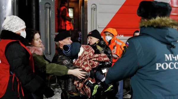 Сотрудники МЧС РФ и волонтеры помогают сойти с поезда жителям Донецкой и Луганской народных республик, прибывшим на железнодорожный вокзал в Нижний Новгород