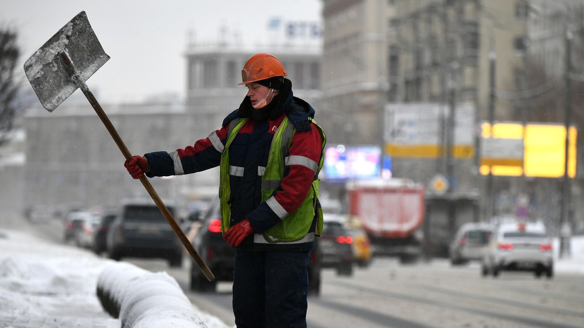 Сотрудник коммунальной службы убирает снег на одной из улиц в Москве - РИА Новости, 1920, 29.03.2022