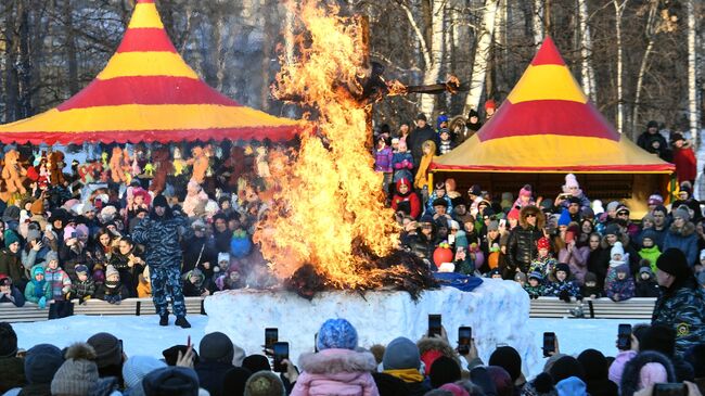 Сжигание чучела во время празднования Широкой Масленицы в Центральном парке Новосибирска