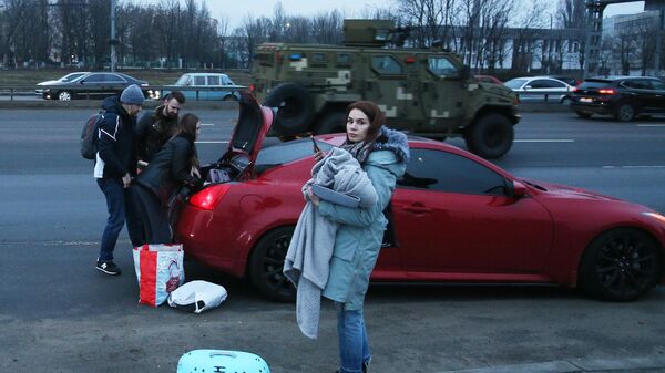 Люди свои вещи в машину на одной из улиц в Киеве