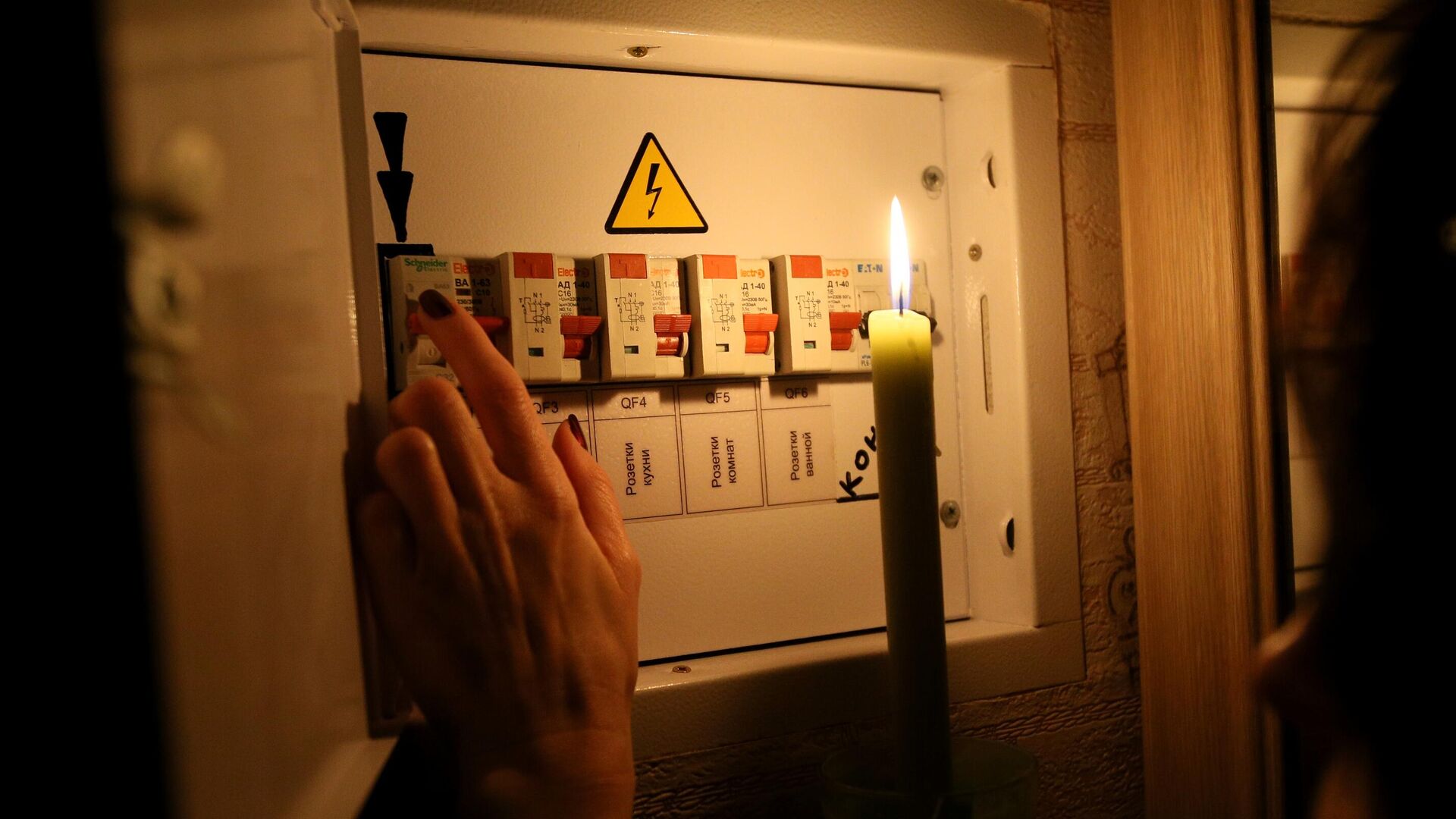 Девушка у электрического щитка в своей квартире во время тестового отключения электричества в Киеве - РИА Новости, 1920, 25.10.2022