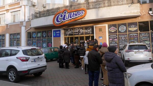 Люди стоят в очереди в продуктовый магазин на одной из улиц в Одессе