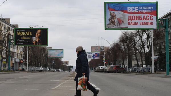 Женщина переходит улицу в Луганске
