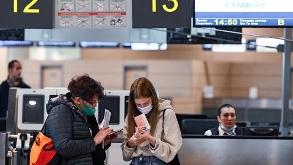 Женщины у стойки регистрации в аэропорту Домодедово в Москве