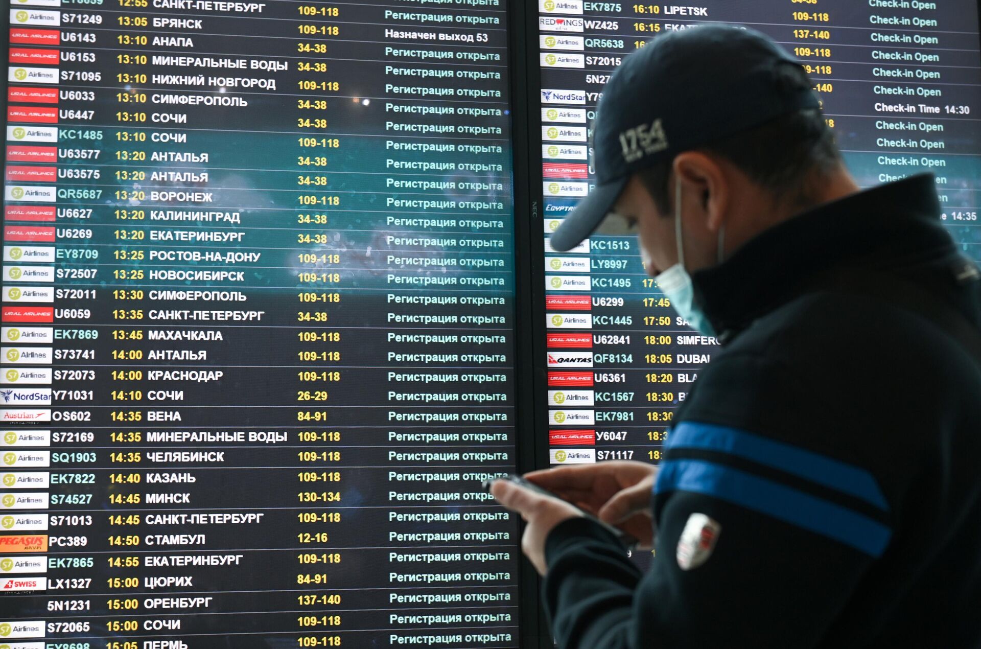 Мужчина возле электронного табло вылетов в аэропорту Домодедово в Москве - РИА Новости, 1920, 25.02.2022