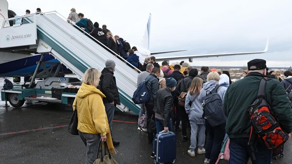 Пассажиры поднимаются по трапу на борт самолета в аэропорту Домодедово в Москве