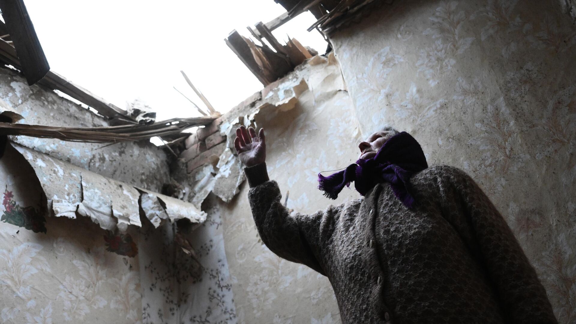 Местная жительница в одной из комнат дома, разрушенного после обстрела поселка Зайцево в Горловке - РИА Новости, 1920, 26.02.2022
