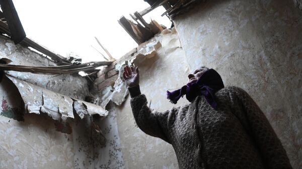 Местная жительница в одной из комнат своего дома, разрушенного после обстрела поселка Зайцево