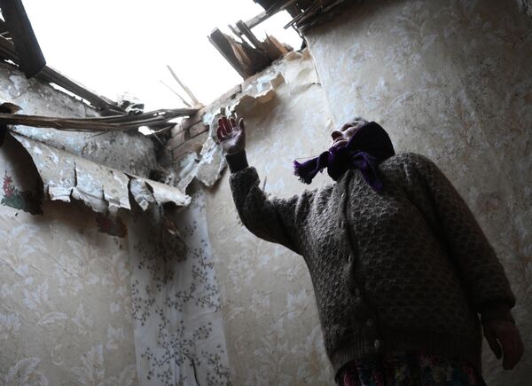 Местная жительница в одной из комнат своего дома, разрушенного после обстрела поселка Зайцево в Горловке