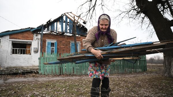 Местная жительница возле своего дома, разрушенного после обстрела поселка Зайцево в Горловке