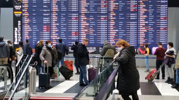 Пассажиры у табло вылетов в аэропорту Шереметьево в Москве