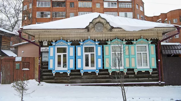 Wooden architecture against the background of modern brick high-rise buildings in Tomsk