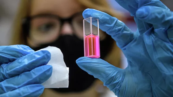 Laboratory assistant with a test tube in the laboratory of photophysics and photochemistry of molecules of the Siberian Institute of Physics and Technology, TSU