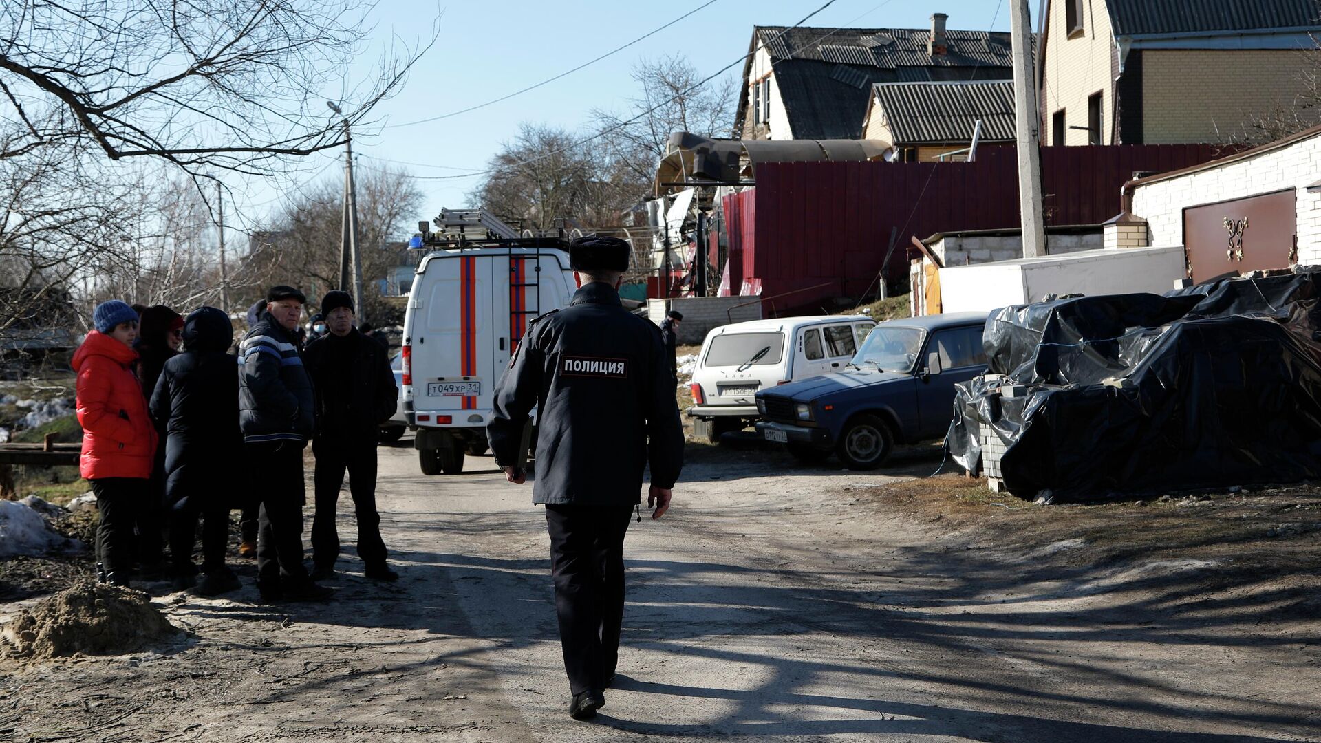 Сотрудник полиции на месте попадания снаряда в жилой дом в Белгороде - РИА Новости, 1920, 25.02.2022