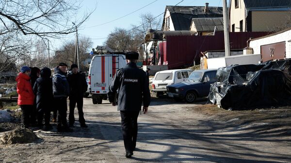 Сотрудник полиции на месте попадания снаряда в жилой дом в Белгороде