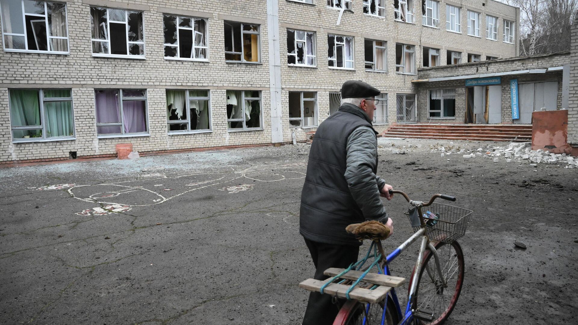 Мужчина у здания школы в Горловке, поврежденной в результате обстрела - РИА Новости, 1920, 28.02.2022