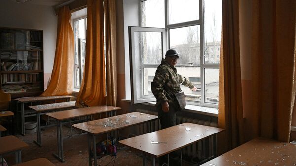 Сотрудник народной милиции ДНР в учебном классе школы Горловки, поврежденной в результате обстрела