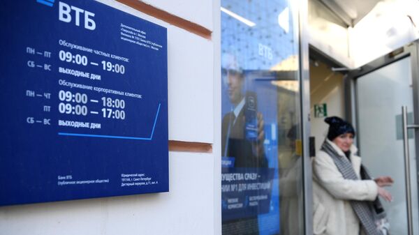 Женщины выходит из офиса ВТБ банка в Москве