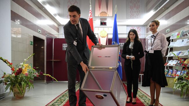 Члены участковой комиссии опечатывают урну для голосования на Республиканском референдуме по внесению изменений и дополнений в конституцию Белоруссии