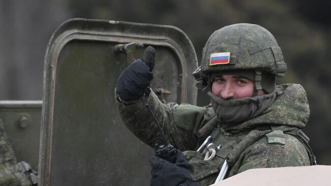 Российский военнослужащий в колонне военной техники