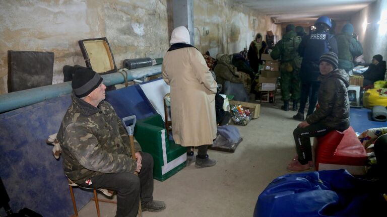 Жители Николаевки, бойцы народной милиции Донецкой народной республики и журналисты укрываются в подвале здания