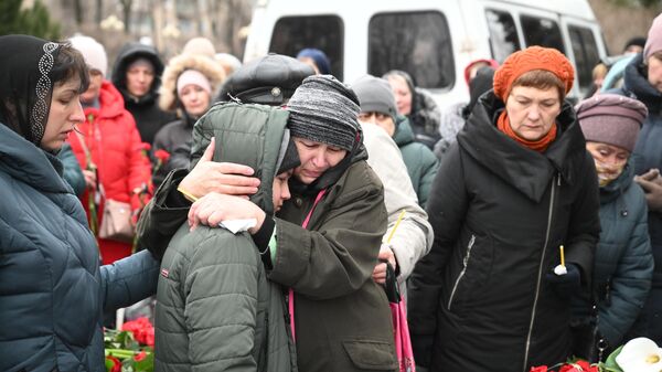 Родные и близкие во время прощания с погибшим при обстреле украинскими войсками здания школы в Горловке в ДНР