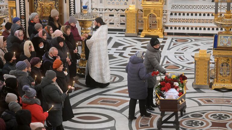 Родные и близкие во время прощания с погибшим при обстреле украинскими войсками здания школы в Горловке в ДНР