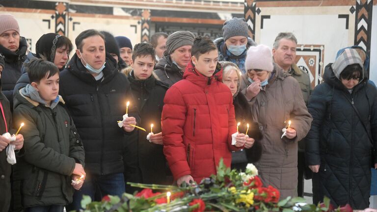 Родные и близкие во время прощания с погибшим при обстреле украинскими войсками здания школы в Горловке в ДНР