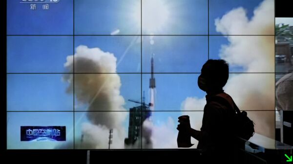 Силуэт мужчины на фоне трансляции запуска ракеты, Пекин