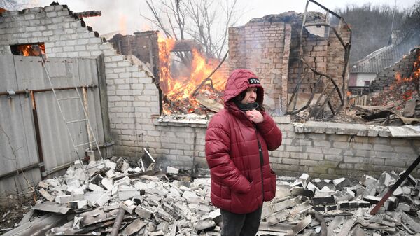 Женщина у жилого дома в Киевском районе Донецка, разрушенном в результате обстрела