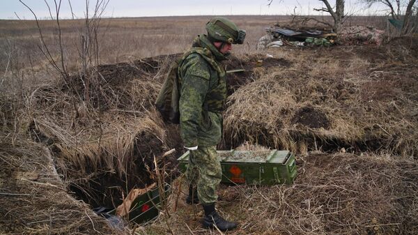 Военнослужащий народной милиции ДНР осматривает брошенные украинской армией боеприпасы