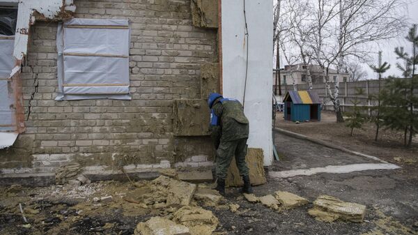 Сотрудник СЦКК у детского сада в станице Луганской, пострадавшего в результате обстрела