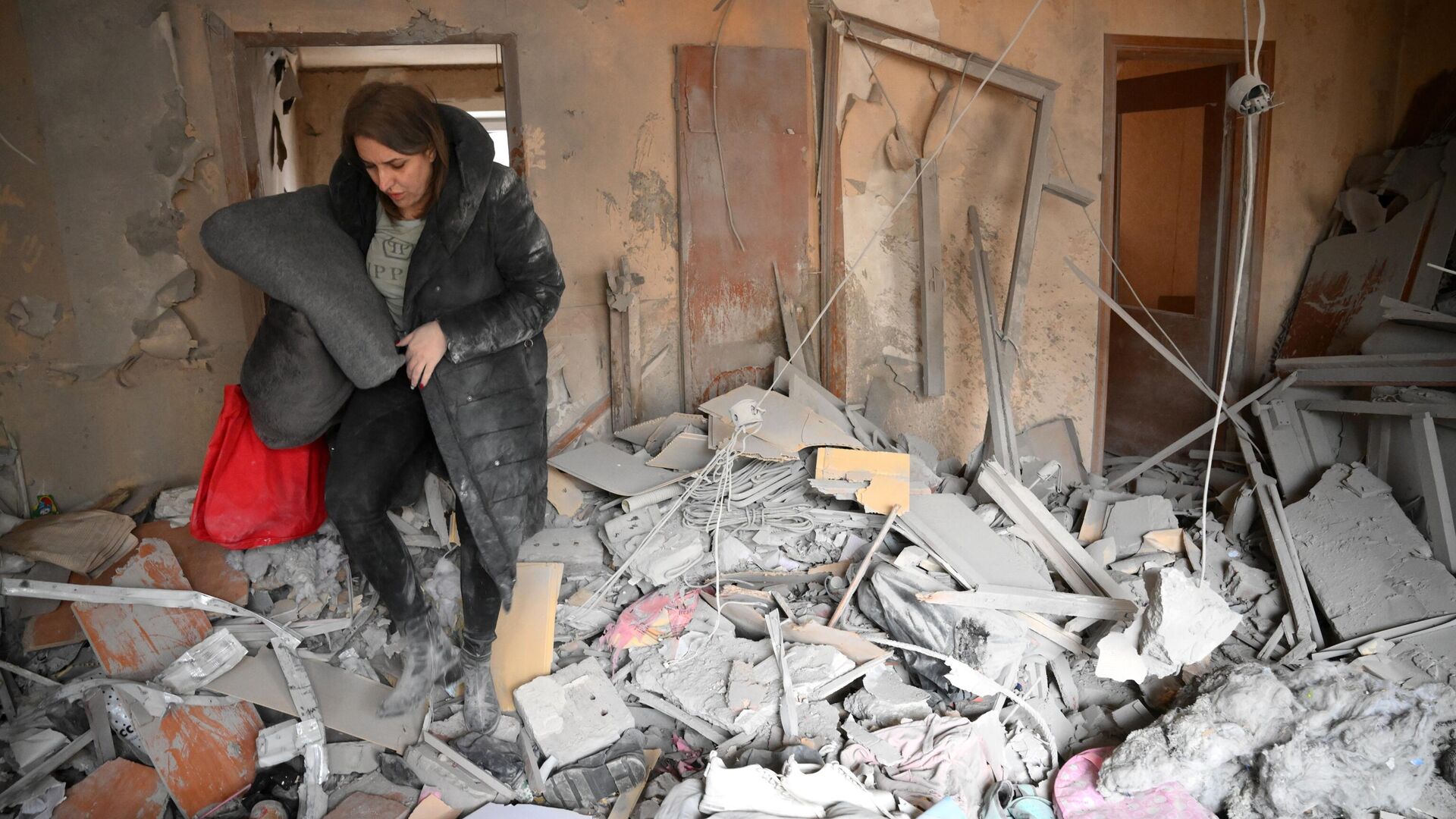 Женщина в квартире, разрушенной в результате прямого попадания снаряда в жилой дом в Горловке - РИА Новости, 1920, 08.05.2022