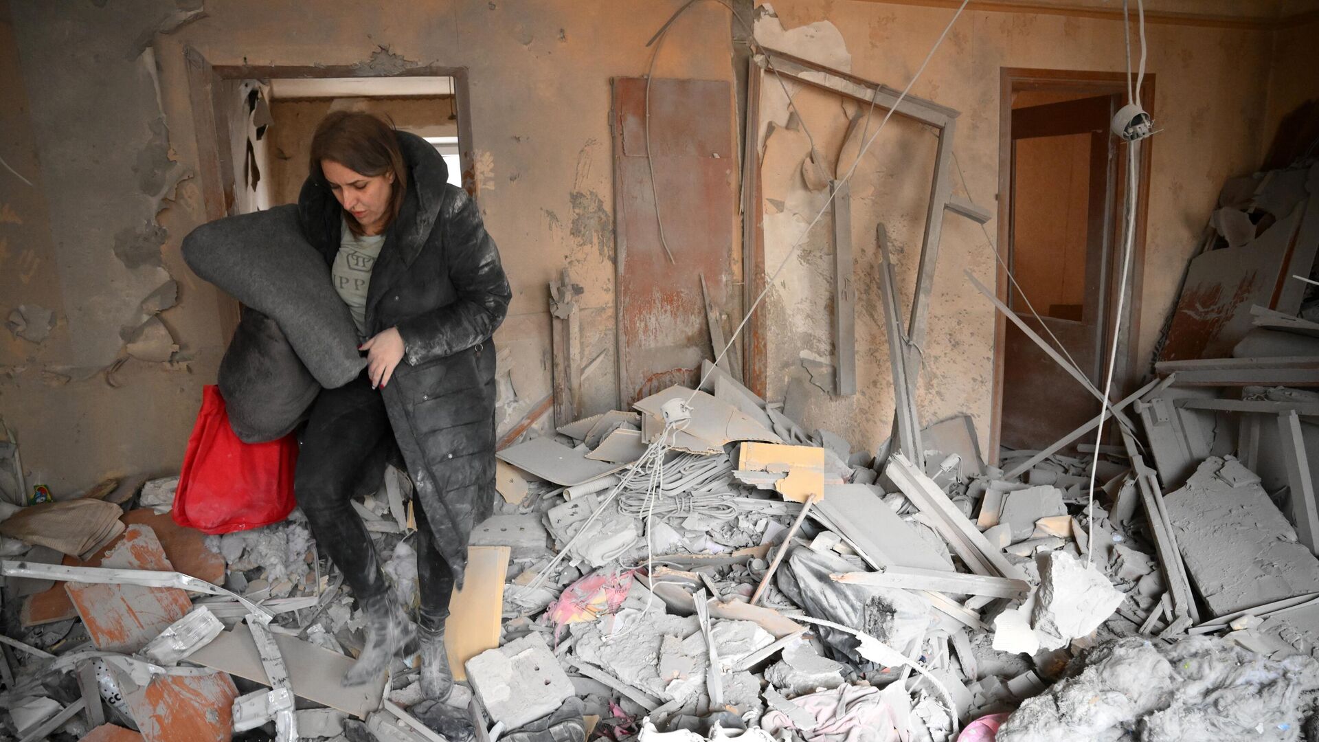 Женщина в квартире, разрушенной в результате прямого попадания снаряда в жилой дом в Горловке - РИА Новости, 1920, 08.05.2022