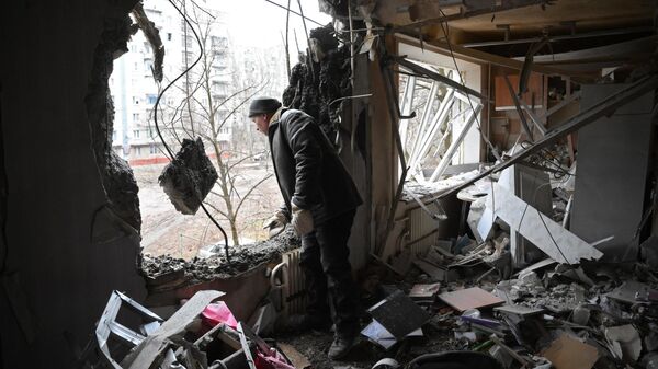 Мужчина в квартире, разрушенной в результате прямого попадания снаряда в жилой дом в Горловке