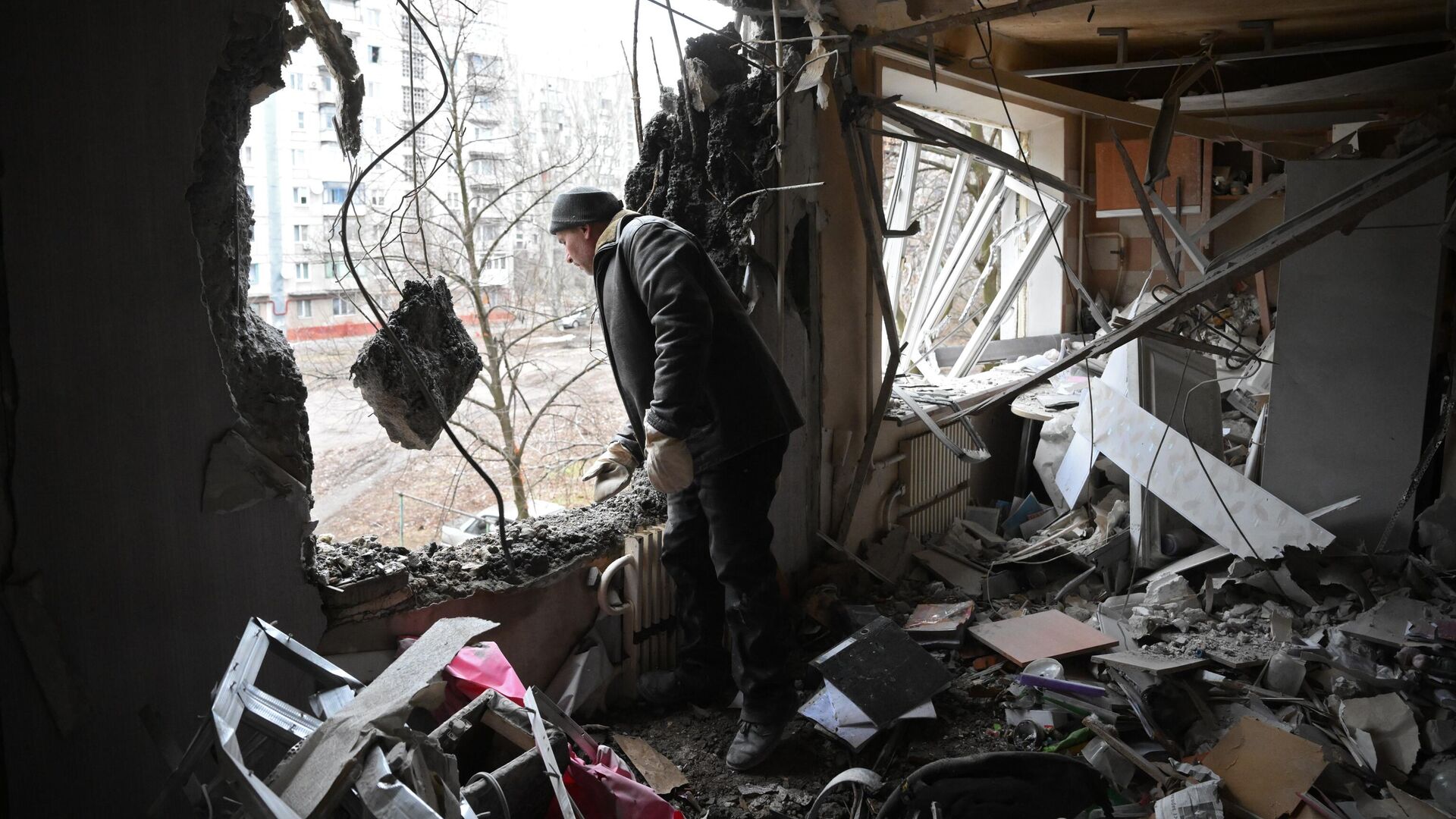 Мужчина в квартире, разрушенной в результате прямого попадания снаряда в жилой дом в Горловке - РИА Новости, 1920, 03.04.2022
