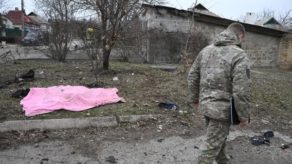 Военнослужащий у трупа сотрудника газовой службы, погибшего в результате обстрелов в Киевском районе Донецка